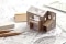 The picture shows construction drawings and a model house as a typical example of the planning of a new building with a heat pump.